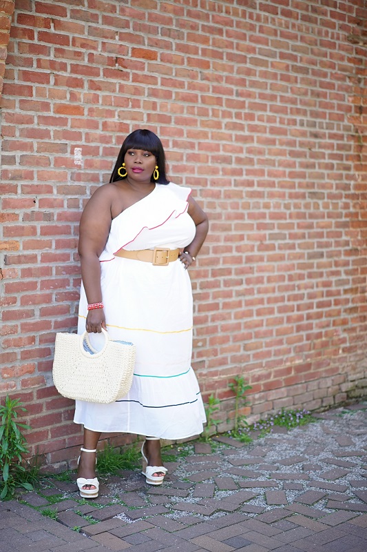 Lane Bryant spring dresses. Chic Style Edit in a white one shoulder ruffled hem dress with wedges and a straw bag